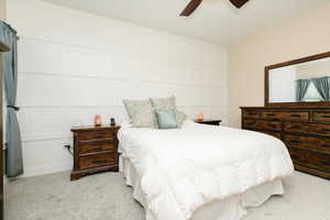 Bedroom with light colored carpet and a ceiling fan