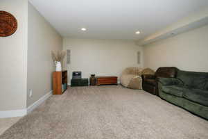 Living room with light carpet, recessed lighting, and baseboards