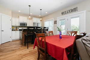 Dining area with light wood-style flooring and recessed lighting