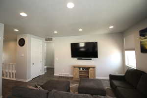Living area with recessed lighting, baseboards, and dark wood-style flooring