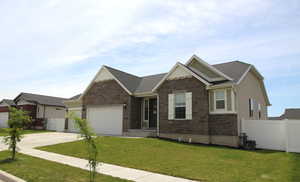 Craftsman-style house with stone siding, an attached garage, and driveway