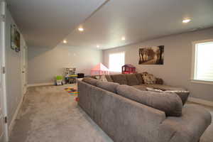 Living room featuring baseboards, light carpet, and recessed lighting