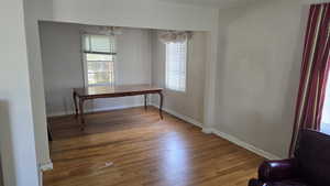Home office featuring wood finished floors, plenty of natural light, and baseboards