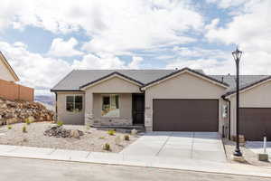 Single story home featuring stucco siding, an attached garage, driveway, a tiled roof, and stone siding