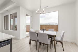 Dining space featuring a chandelier, light wood-style floors, and baseboards