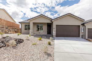 Ranch-style home with an attached garage, stucco siding, driveway, and stone siding