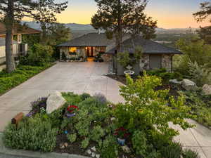 View of front facade featuring stone siding, concrete driveway, and a mountain view