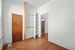 Unfurnished bedroom featuring wood finished floors and baseboards