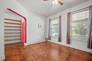 Spare room with wood finished floors, ceiling fan, and baseboards