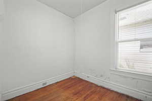 Unfurnished room with dark wood-style floors and baseboards