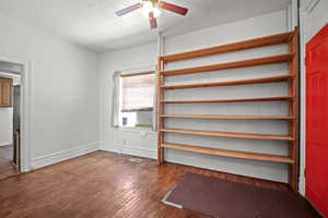 Unfurnished bedroom featuring wood-type flooring, a ceiling fan, and baseboards