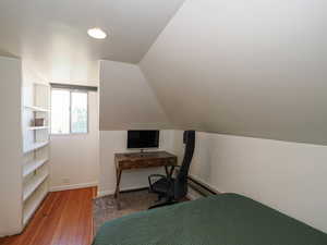 Bedroom featuring hardwood / wood-style flooring, baseboards, lofted ceiling, and recessed lighting
