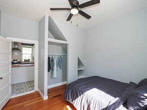Bedroom with a closet, wood finished floors, baseboards, and ceiling fan