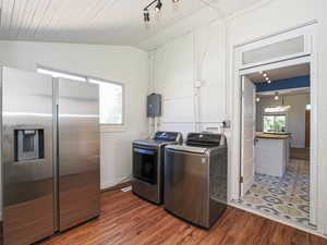 Washroom featuring wood finished floors and washing machine and dryer