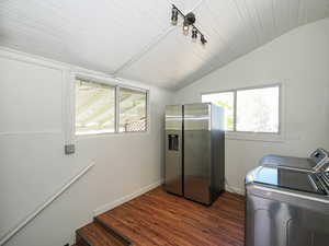 Laundry room with independent washer and dryer, dark wood-style flooring, and baseboards
