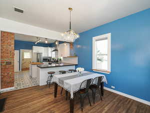 Dining room featuring baseboards, wood finished floors, and a chandelier