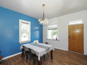 Dining space featuring a chandelier, plenty of natural light, wood finished floors, and baseboards