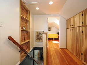 Hallway featuring an upstairs landing, light wood-type flooring, recessed lighting, lofted ceiling, and baseboards