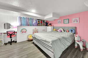 Bedroom featuring a textured ceiling, wood finished floors, and recessed lighting