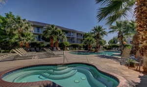 Community pool with a patio area and a hot tub
