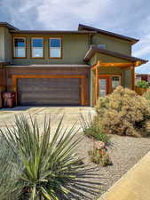 View of front of house featuring stucco siding, driveway, and an attached garage