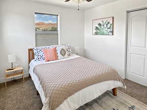 Carpeted bedroom with a ceiling fan