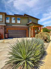 View of front of home featuring a garage, stucco siding, and driveway