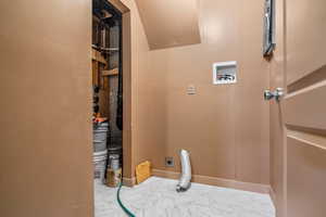 Laundry room with electric dryer hookup, hookup for a washing machine, marble look tile flooring, and baseboards