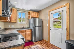 Kitchen with freestanding refrigerator, a sink, light wood finished floors, plenty of natural light, and recessed lighting