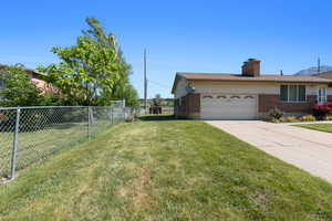 View of yard with a garage and concrete driveway