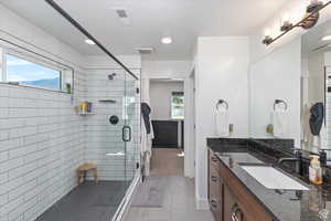 Bathroom with vanity, a stall shower, tile patterned floors, and recessed lighting