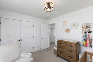 Bedroom with light carpet and a closet