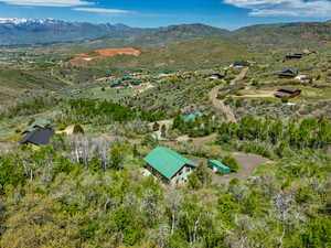 Aerial view of property and surrounding area featuring a mountainous background