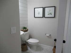 Bathroom featuring toilet, tile patterned floors, and baseboards