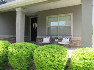 Doorway to property featuring stone siding and stucco siding