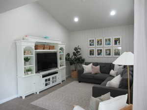 Living area featuring carpet flooring, vaulted ceiling, recessed lighting, and baseboards
