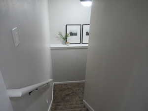 Staircase featuring carpet and baseboards