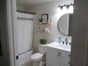 Bathroom with vanity, toilet, tile patterned flooring, and shower / bath combo