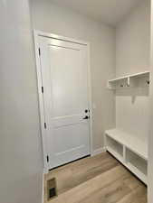 Mud room area with back pack rack right off of the garage