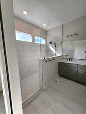 Fully tiled super shower with windows and vanity with custom cabinets