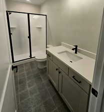 Full bath featuring vanity and a shower stall in the basement