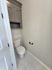 Private water closet in owners bathroom with custom cabinet