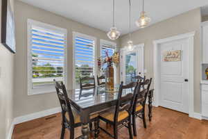 Dining room featuring healthy amount of natural light, light wood-type flooring, and baseboards