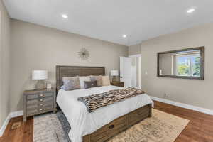 Bedroom with baseboards, wood finished floors, and recessed lighting