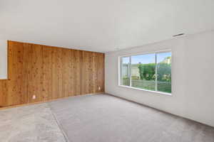Spare room featuring wooden walls
