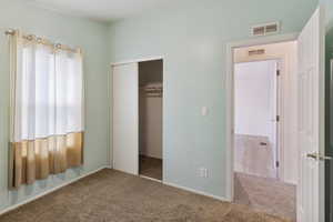Unfurnished bedroom with carpet flooring and a closet