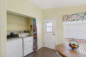Washroom featuring washer and dryer, healthy amount of natural light, and baseboards