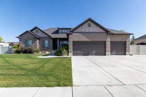 Craftsman house with board and batten siding, an attached garage, concrete driveway, brick siding, and roof with shingles
