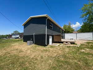 Rear view of property featuring a deck and central AC