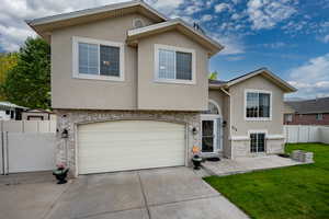 View of front of house featuring stucco siding, concrete driveway, an attached garage, and stone siding